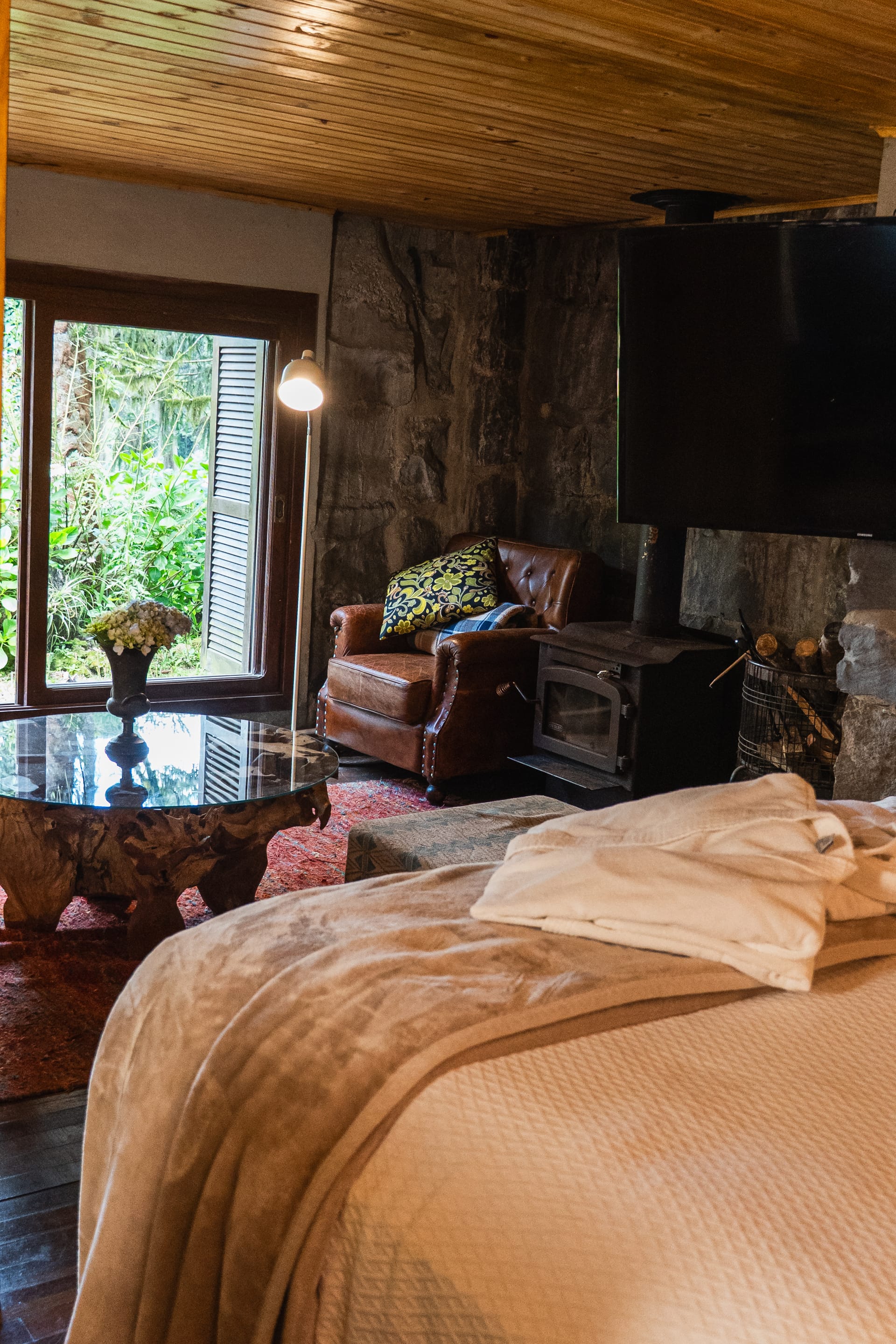 Quarto com fogão a lenha e poltrona de couro